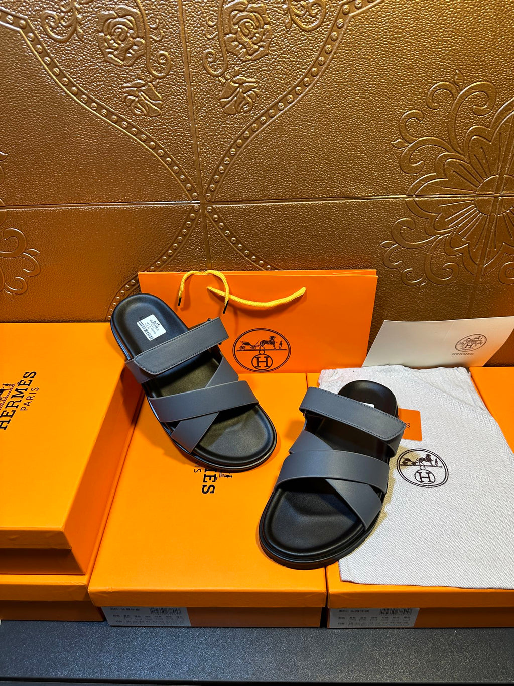 Hermes slide sandals with navy crossover straps and black footbeds, laid out