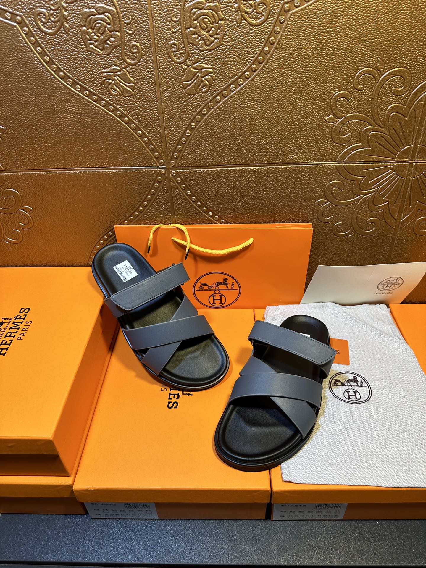 Hermes slide sandals with navy crossover straps and black footbeds, laid out