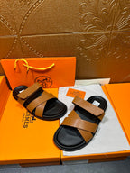 Hermes sandals pair with tan wide straps and black footbeds on box