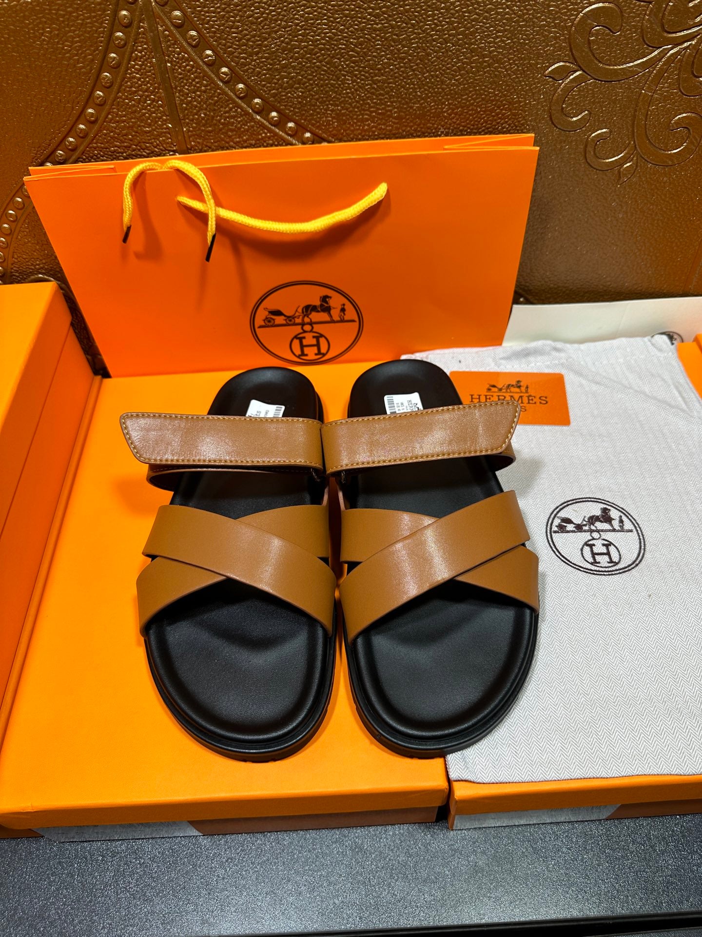 Hermes slide sandals with tan leather crisscross straps and black footbed