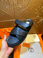 Black leather slide sandals with wide top strap and side buckle detail