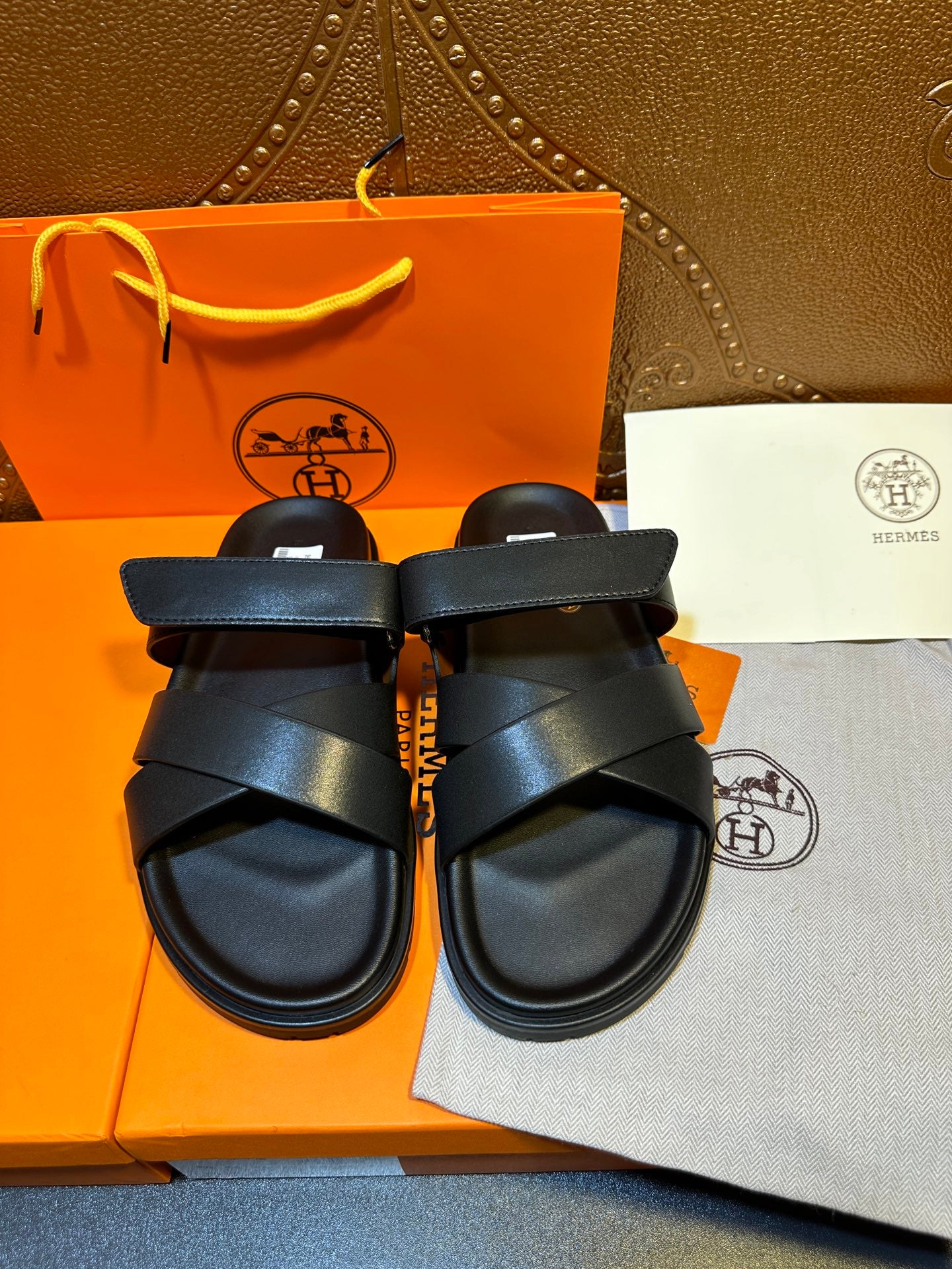 Black leather sandals with two wide straps across the foot and buckle closure