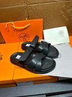 Black leather sandals with thick cross straps and textured footbed