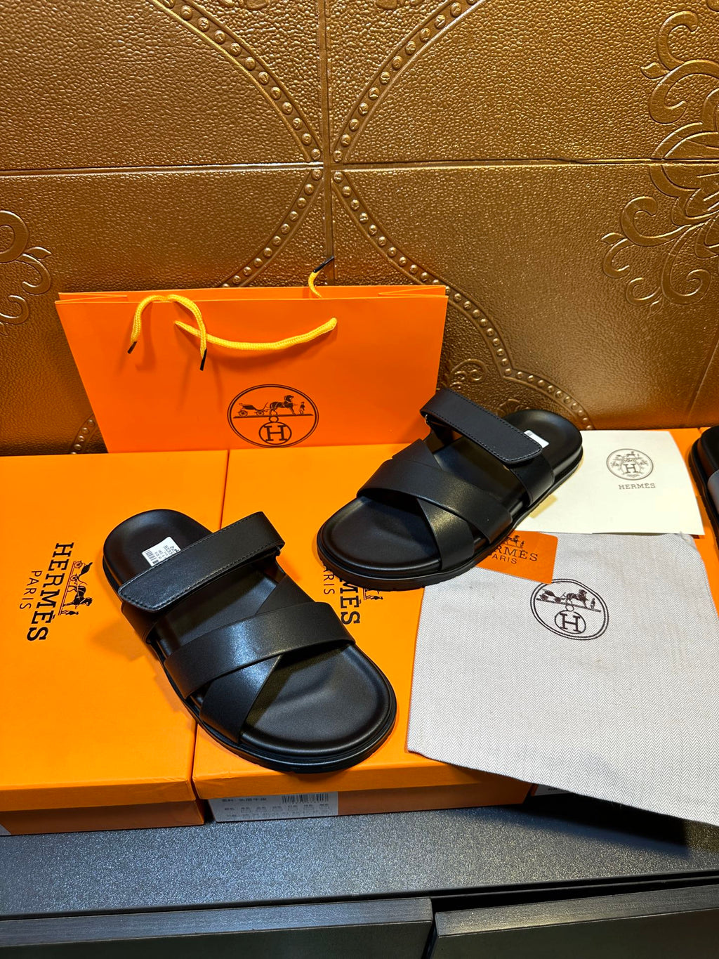 Pair of black slide sandals with two broad straps and adjustable buckle