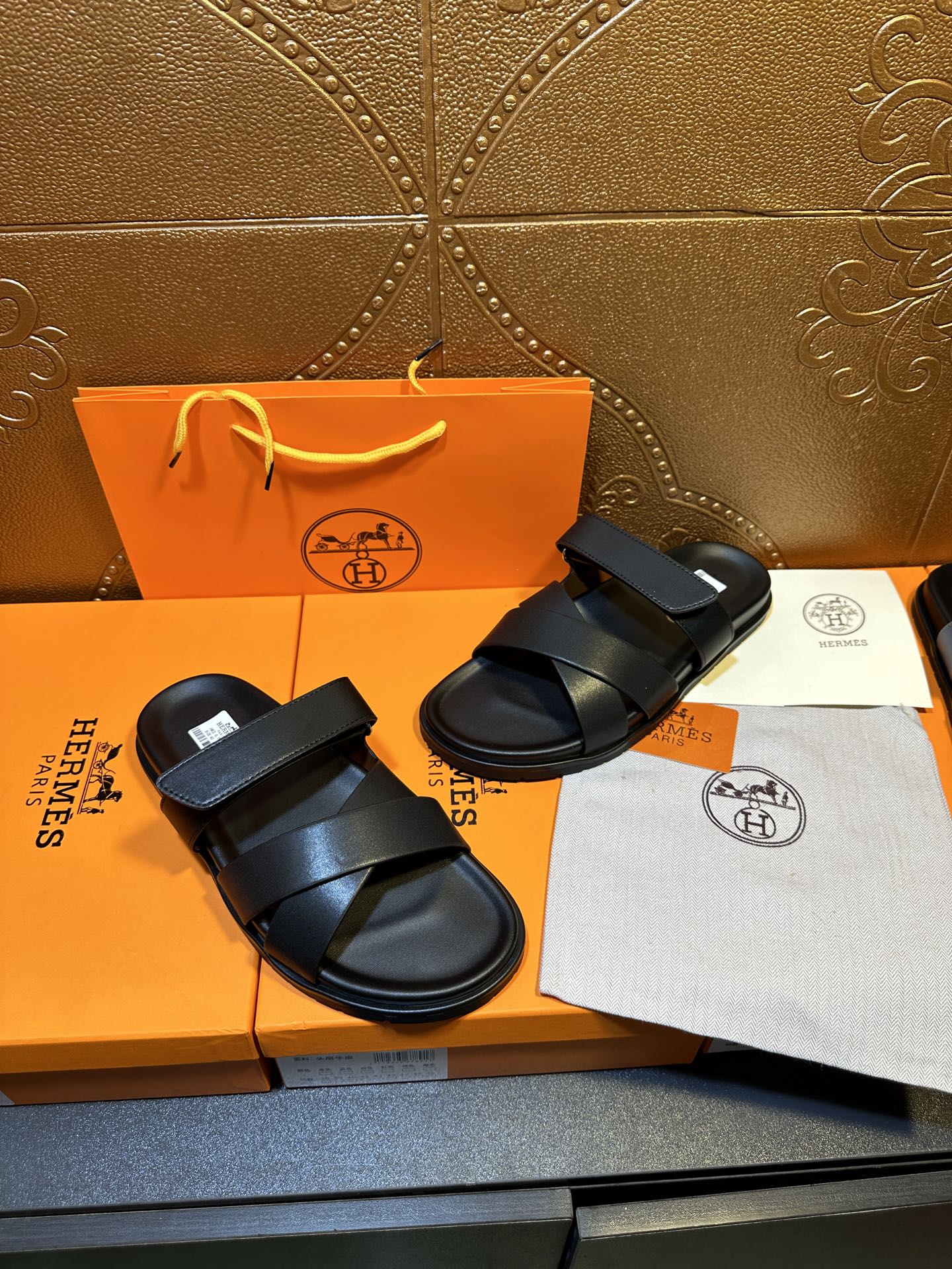 Pair of black slide sandals with two broad straps and adjustable buckle