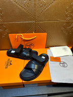Black leather sandals with stacked cross straps and open-toe silhouette