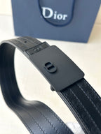 Leather belt with textured navy strap and large dark buckle with CD motif