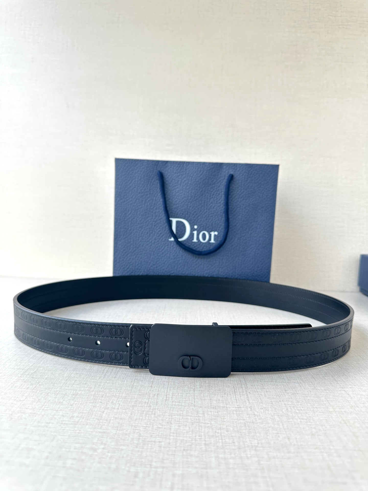 Leather belt in dark blue with rectangular buckle featuring a CD emblem