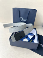White leather belt with dark buckle featuring oval logo, strap on display