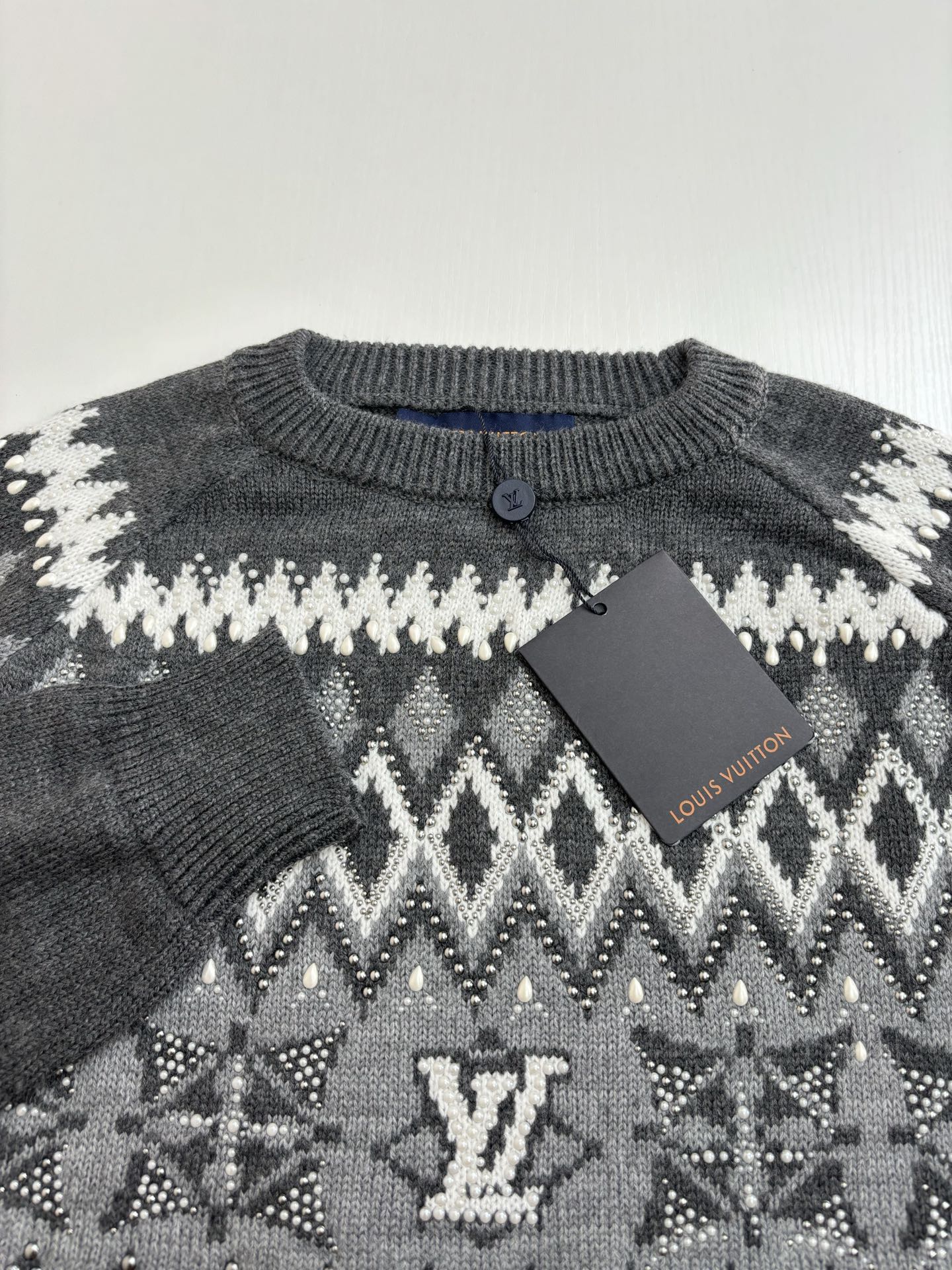 Knit sweater neckline with button placket; dark gray with white pattern and LV detail
