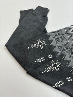 Folded dark gray knit sweater with white fair isle pattern and decorative motifs