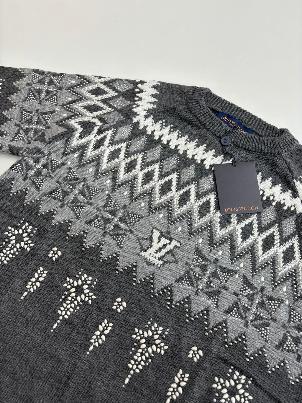 Dark gray sweater knit with geometric fair isle pattern; Louis Vuitton tag on chest