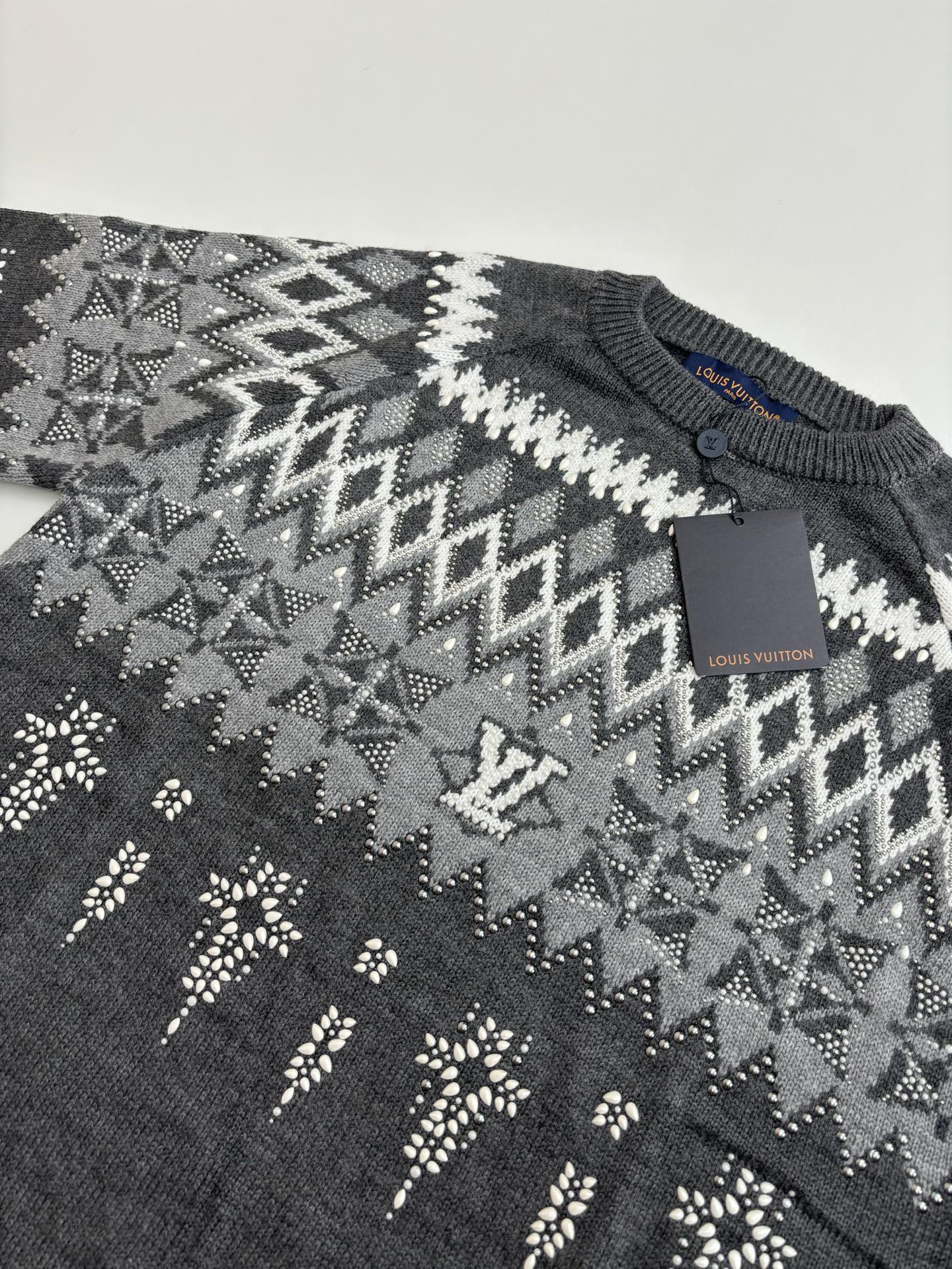Dark gray sweater knit with geometric fair isle pattern; Louis Vuitton tag on chest