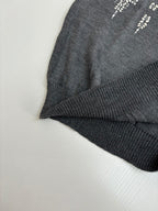 Dark gray sweater sleeve cuff and ribbed hem with white motif detailing