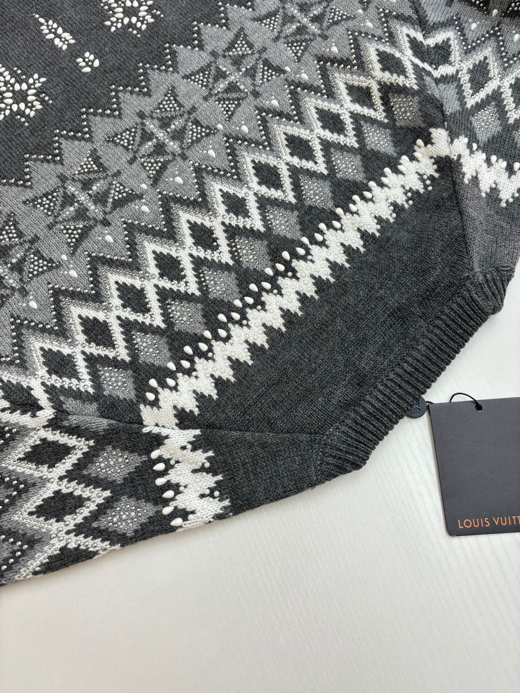 Dark gray knit sweater shoulder with zigzag fair isle pattern; Louis Vuitton tag