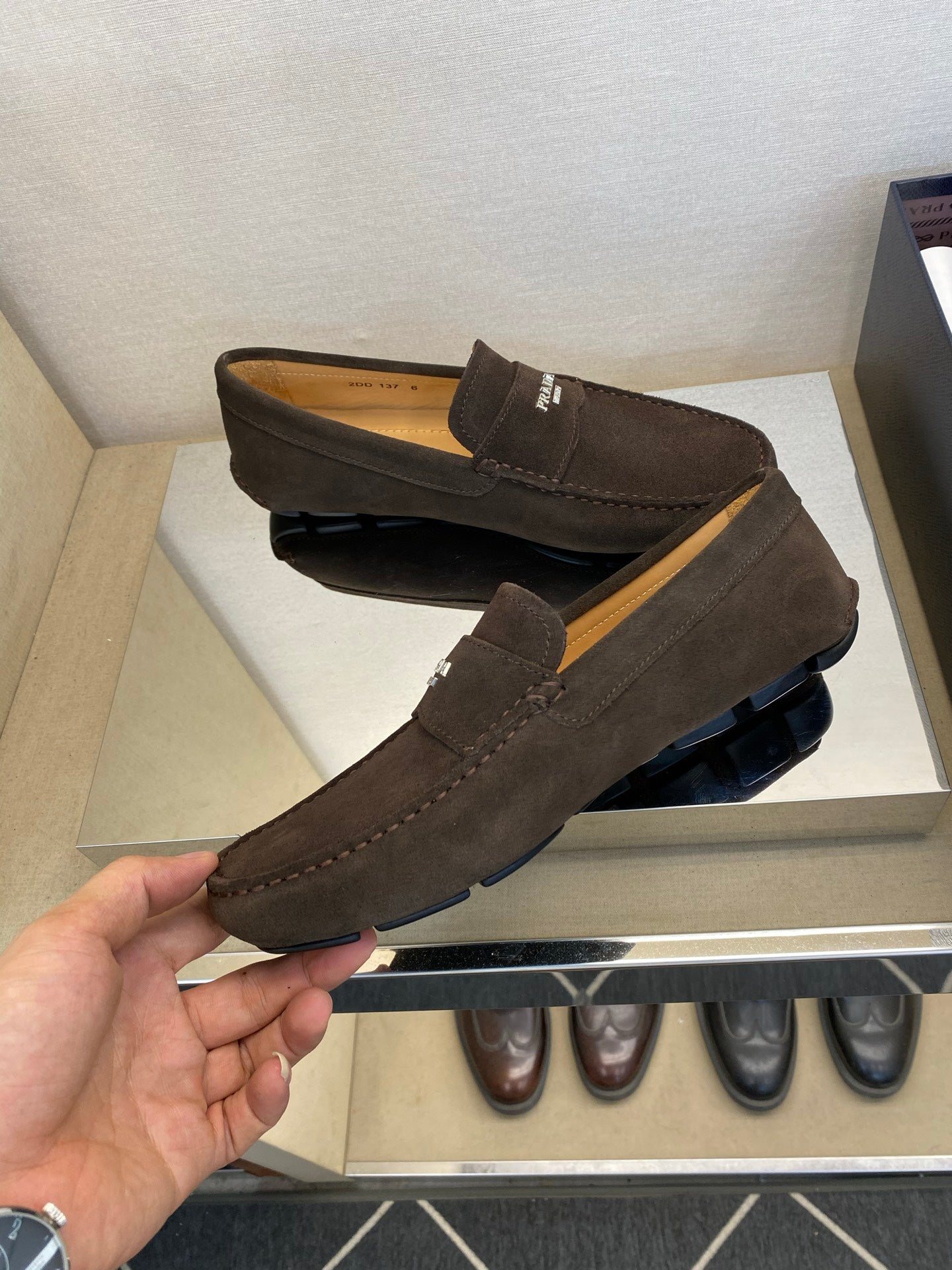 Brown suede loafers with Prada logo strap and stitched trim, pair view