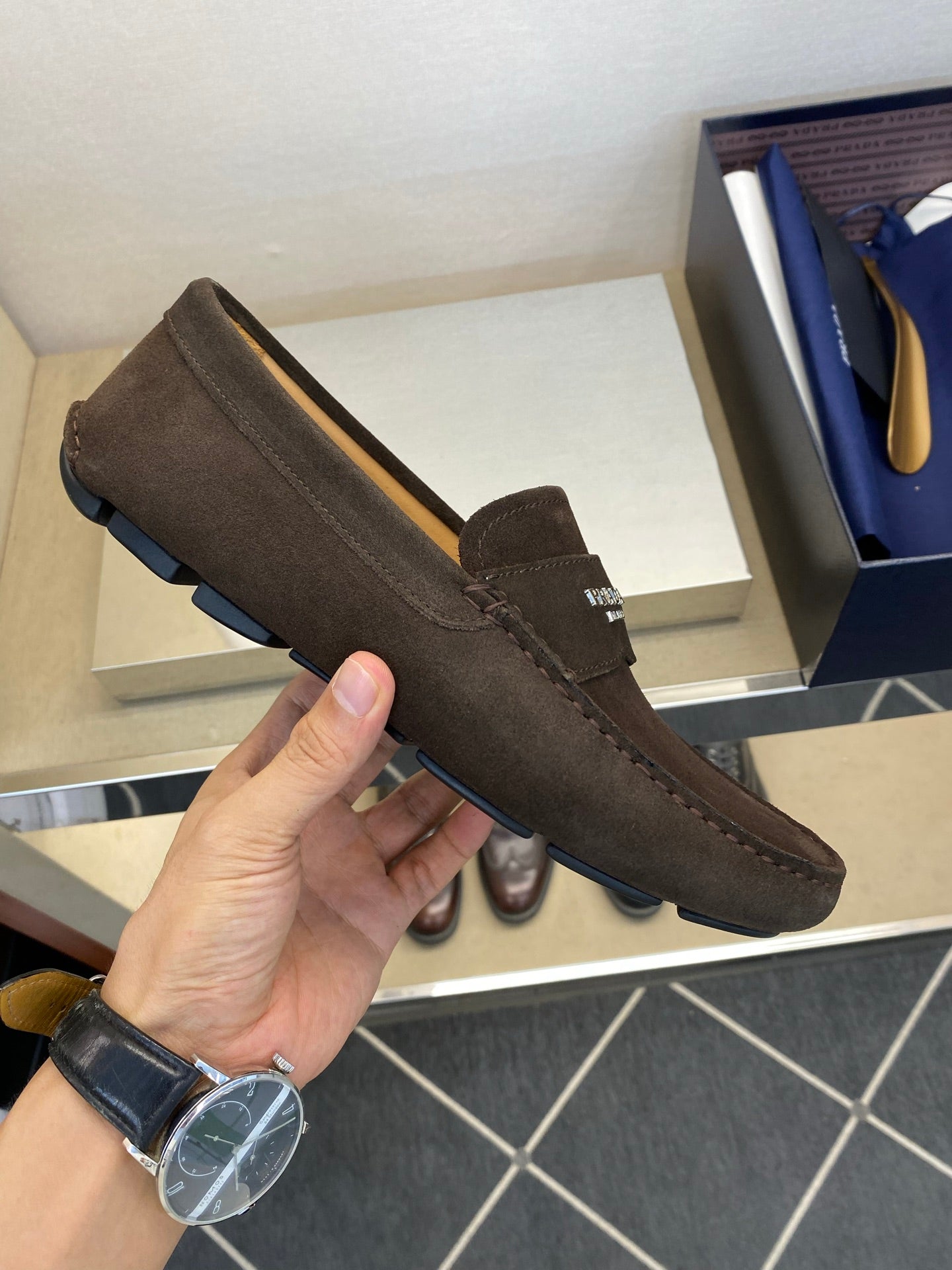 Brown suede loafer with low profile sole and slip-on strap, stitched moccasin