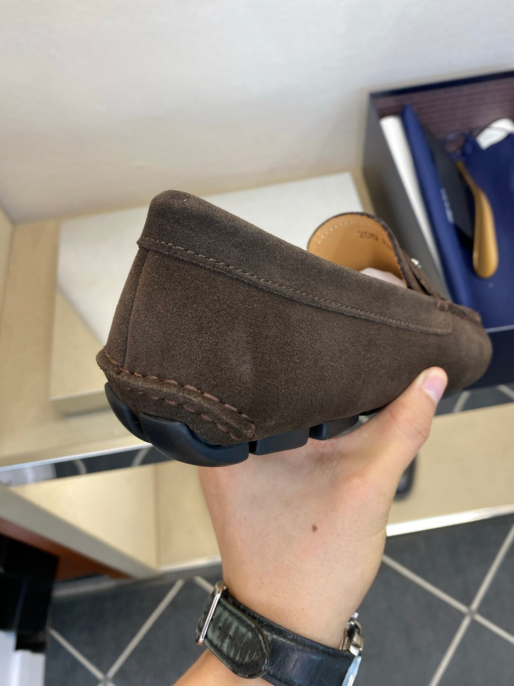 Brown suede loafer with Prada logo strap, rounded toe and stitched sole edge