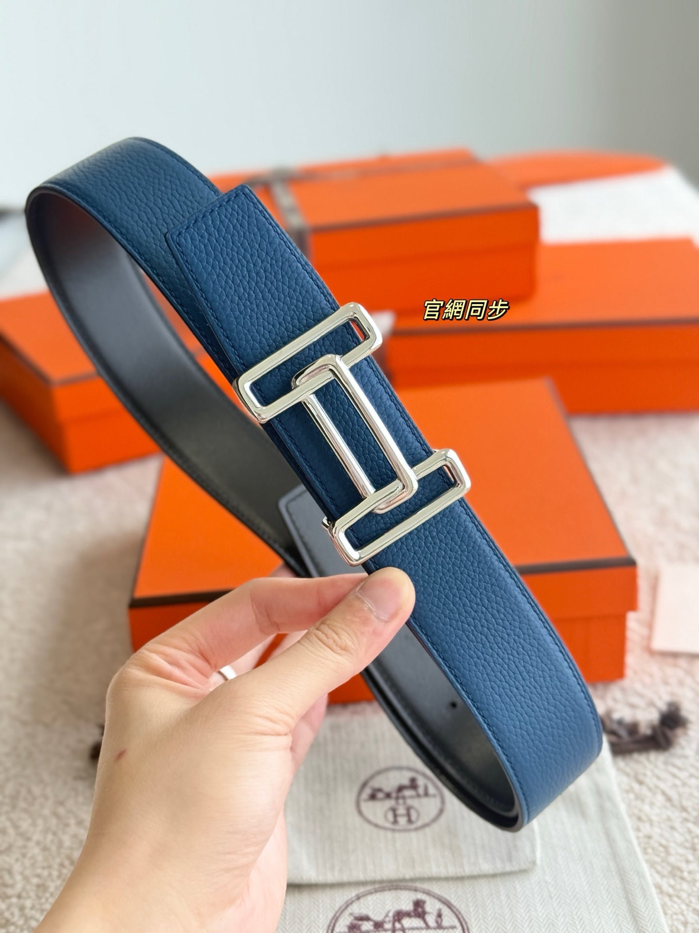 Hermes reversible leather belt close-up with blue strap, silver buckle, and dark lining