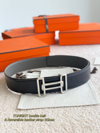 Hermes reversible belt, dark gray leather strap with silver buckle, shown flat on pouch