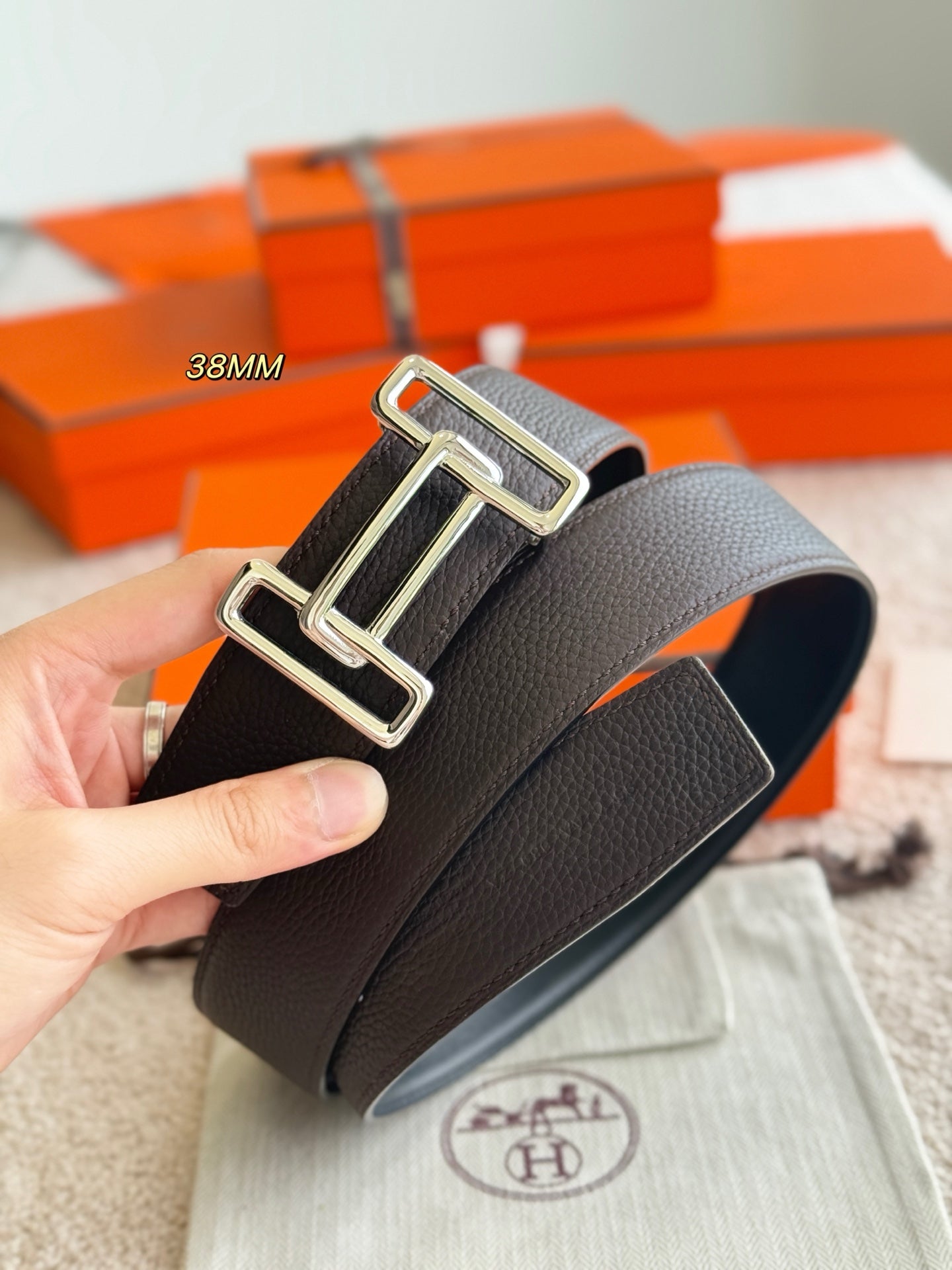 Hermes belt strap with silver-toned buckle hardware, curved edge visible