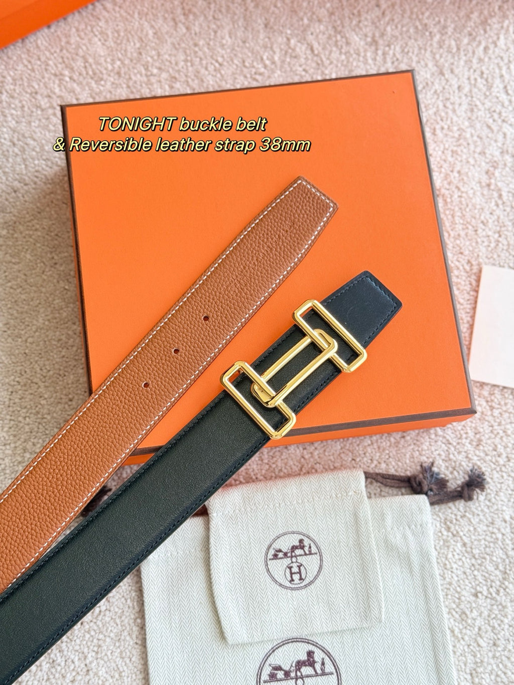 Reversible leather belt with gold-tone buckle, tan strap and dark strap shown