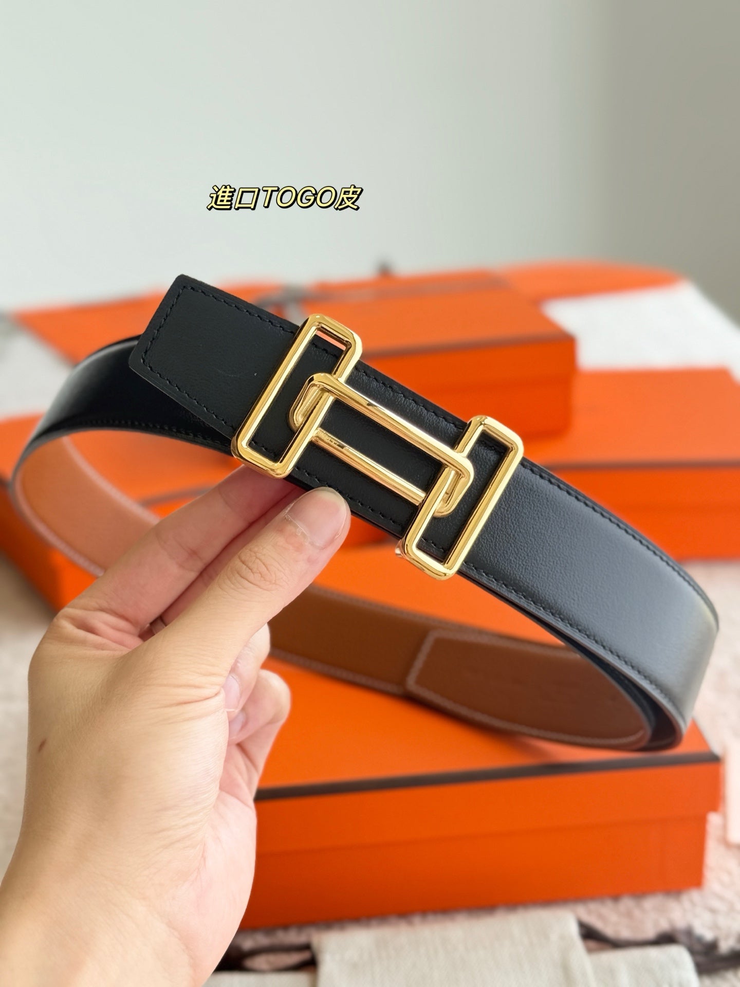 Reversible leather belt with gold-tone buckle, dark leather strap with stitched edges