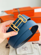 Blue leather belt close-up with gold-tone buckle