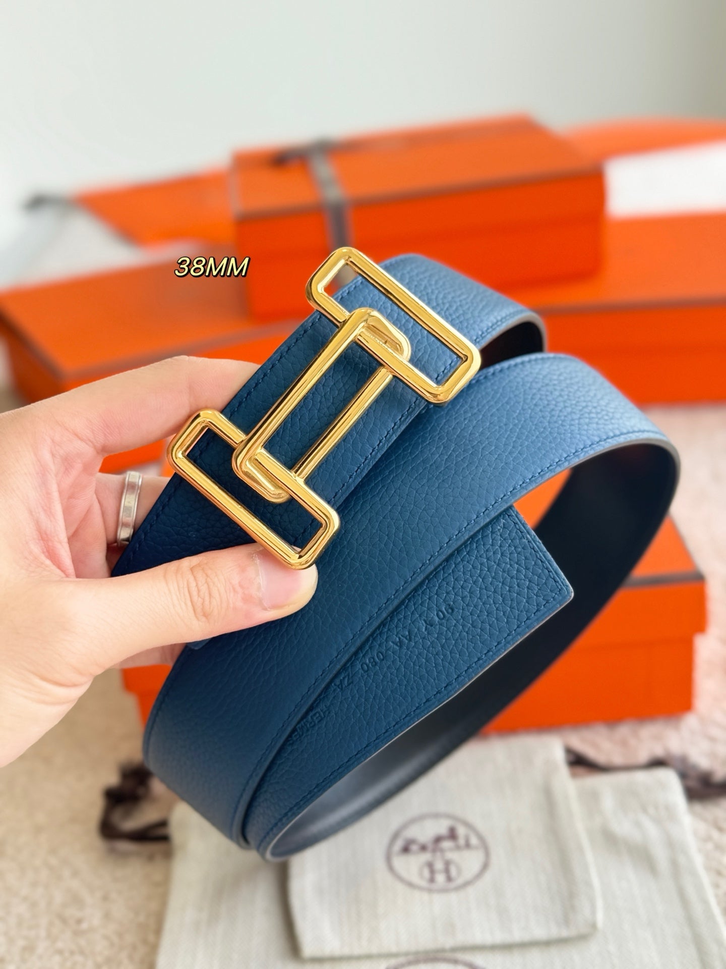 Blue leather belt close-up with gold-tone buckle