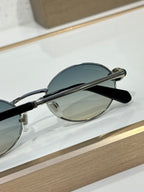 Round sunglasses side view with silver frame, blue-tinted lens, black temple