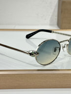 Round sunglasses with silver metal frame, blue-tinted lenses, and black temple