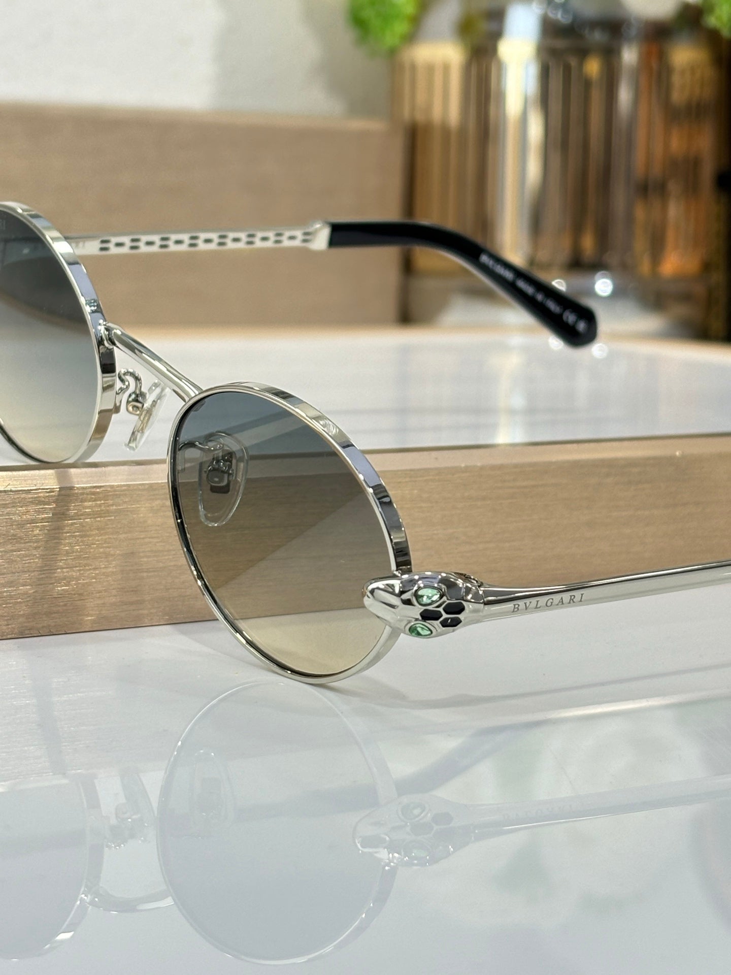 Round sunglasses with silver metal frame, blue lenses, and black temple