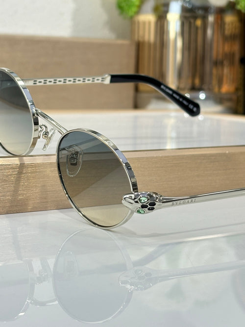 Round sunglasses with silver metal frame, blue lenses, and black temple