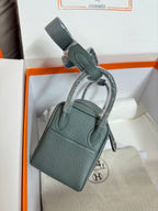 Hermes bag, dark teal textured leather, short handle with strap loops, boxed display.