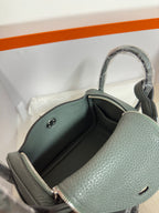 Hermes bag interior close-up, dark lining, gold zipper, pebbled leather side wall.