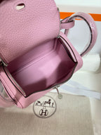 Pink leather handbag open interior with zip closure and stitched lining pocket.