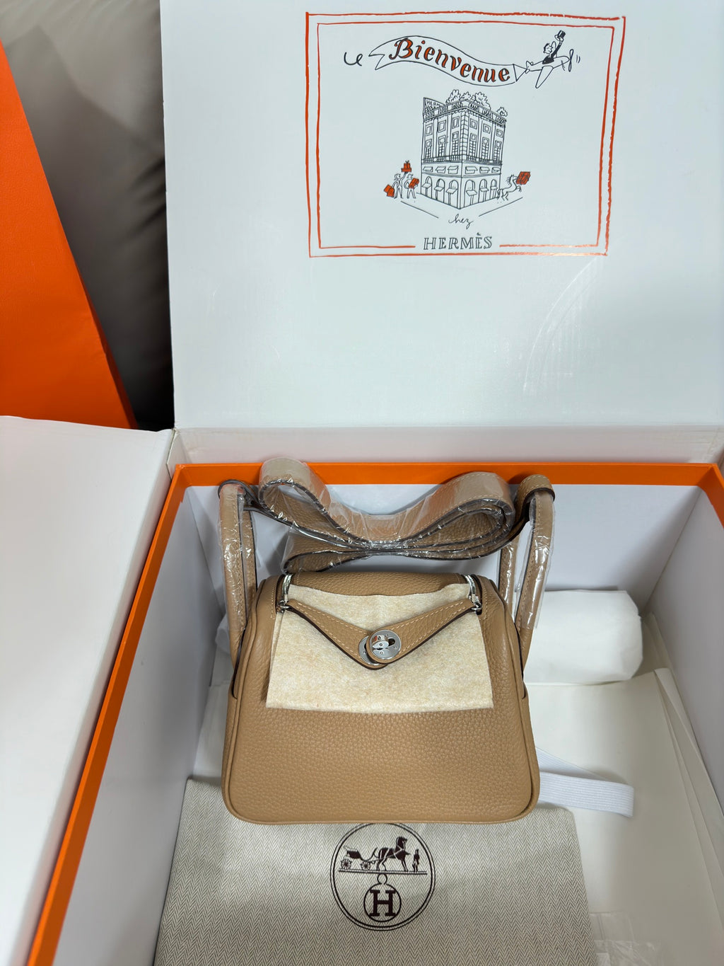 Hermes beige leather mini bag with front flap and silver-tone hardware, top handle straps