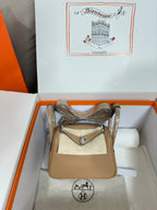 Hermes beige leather mini bag with front flap and silver-tone hardware, top handle straps
