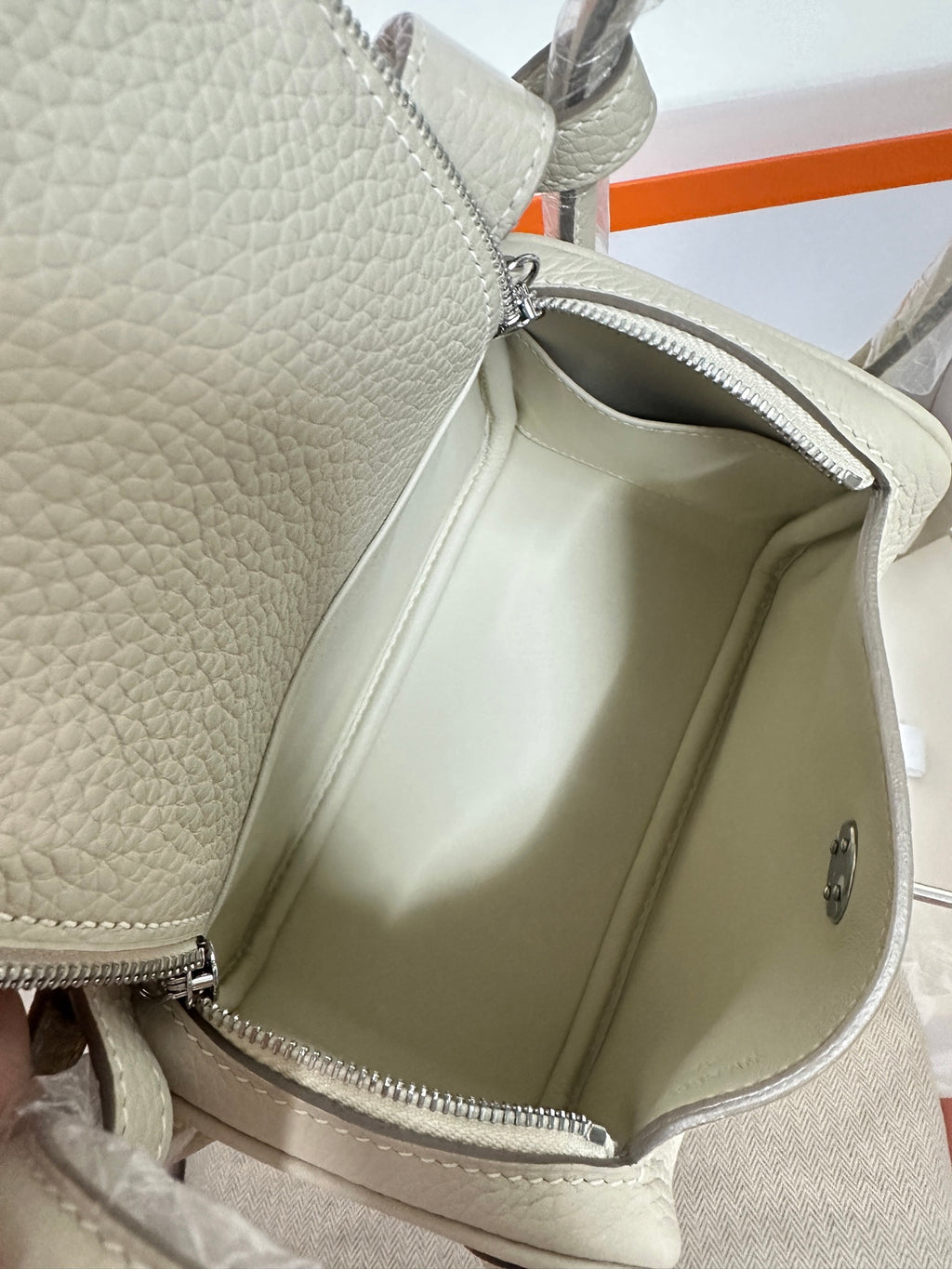 Hermes bag open view showing light beige interior lining and zipper edge