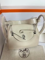 Hermes bag front view in light beige textured leather with metal logo hardware