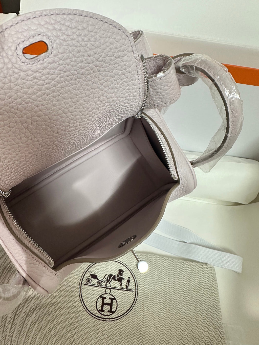 Lilac Hermes handbag top opening with zipper, textured leather and side strap loop
