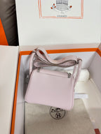 Lilac Hermes mini handbag with top handle and crossbody strap, shown in open gift box
