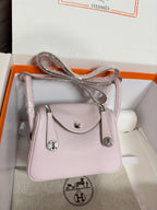 Lilac Hermes handbag with crossbody strap, front flap, and silver-tone clasp hardware