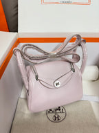 Lilac Hermes handbag with crossbody strap and front flap, silver-tone hardware and logo