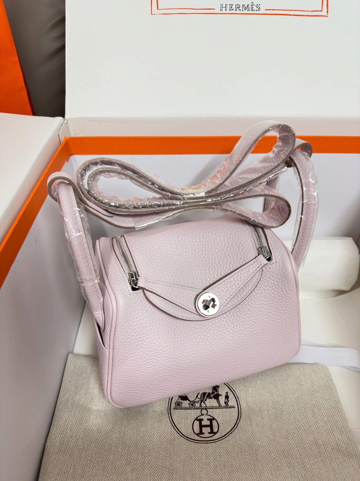 Lilac Hermes handbag with crossbody strap and front flap, silver-tone hardware and logo