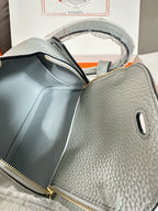 Hermes light blue textured leather mini bag with front zip pocket and gold zipper pulls