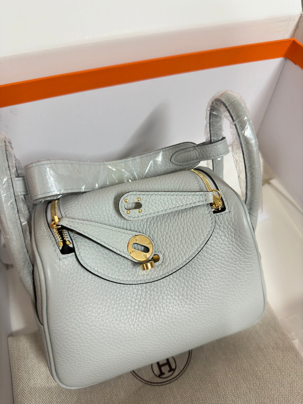 Hermes light blue leather mini bag open to reveal interior lining and gold hardware