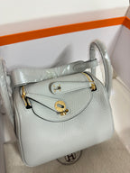 Hermes light blue leather mini bag open to reveal interior lining and gold hardware