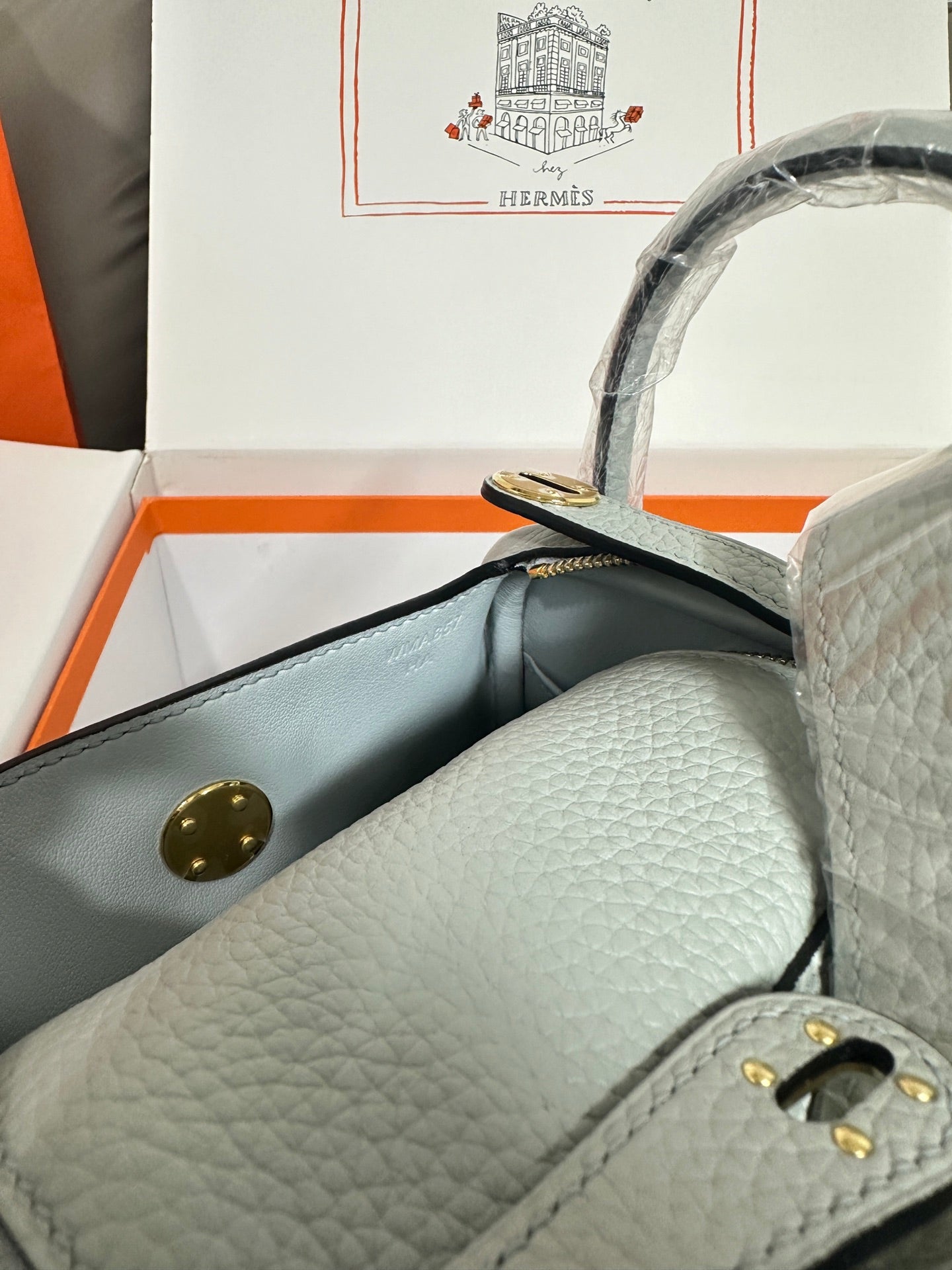 Hermes light blue leather mini bag with gold button tab and interior wall