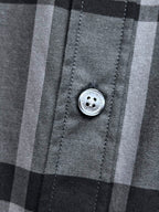 Gray and black plaid button-up shirt close-up of front button
